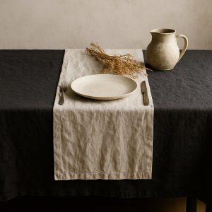 Olé & Co tafellaken van charcoal met tablerunner van Europees linnen. bestek en droogbloemen, bord en kleine melkkan.