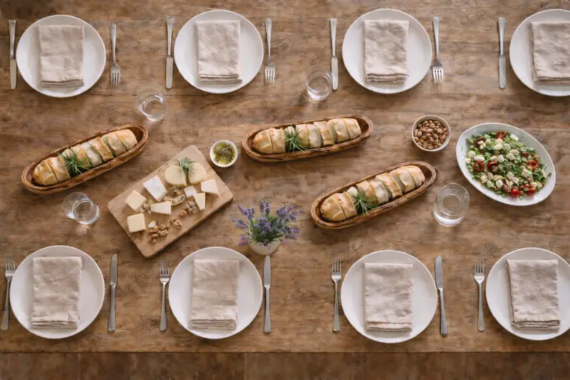 Drie olijfhouten stokbroodschaaltjes op een gedekte tafel voor een mediterrane lunch of diner